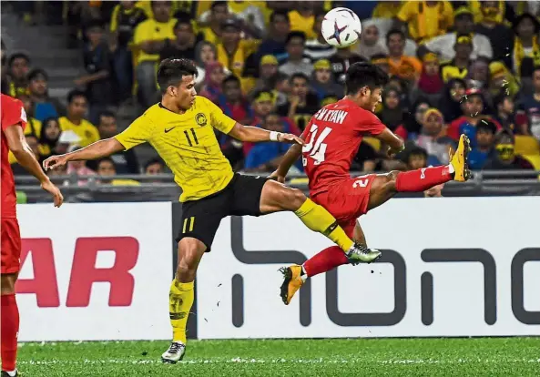  ?? — Bernama ?? Watch your back: Malaysia’s Muhammad Safawi Rasid (left) vying for the ball with Myanmar’s Win Moe Kyaw in the AFF Suzuki Cup Group A match at the National Stadium in Bukit Jalil yesterday.