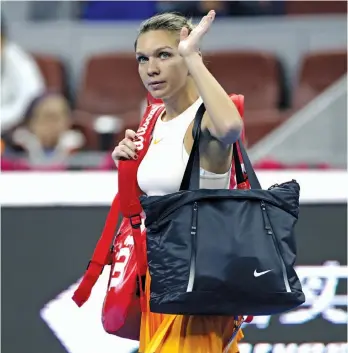  ?? — AP ?? Romania’s Simona Halep waves to spectators after retiring with her back injury during her first round match against Ons Jabeur of Tunisia in the China Open tennis tournament in Beijing on Sunday.