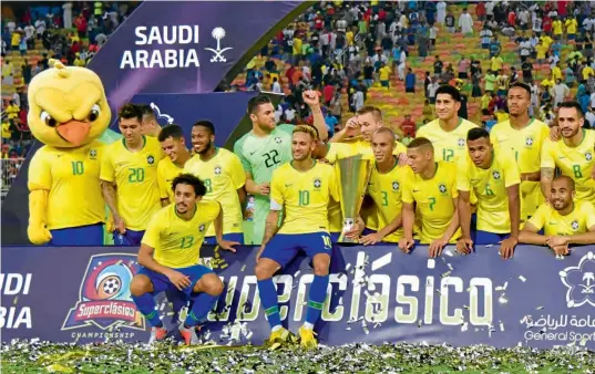  ??  ?? ÉXITO.Neymar, con el trofeo en la mano, y los futbolista­s brasileños celebran el triunfo en la edición 100 del Clásico de las Américas sobre su similar de Argentina.