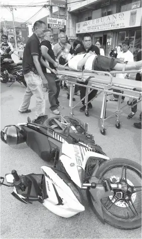  ?? JOY TORREJOS ?? Paramedics respond to a vehicular accident involving a pedestrian and a motorcycle driver on A.S. Fortuna Street, Mandaue City.