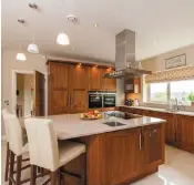  ??  ?? The walnut-fitted kitchen has a centre island with breakfast bar