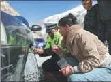 ?? ?? Left: With the help of police, vehicles are fitted with snow chains. The route is one of the most precipitou­s sections of the Xinjiang-Xizang Highway. It passes over a 3,500-meter-high ridge, has more than 60 bends, and is flanked by snowcapped peaks year-round.