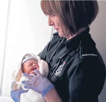  ??  ?? Lisa Elder, of the Scottish Ambulance Service, with baby Ollie who was delivered at home in Cardenden.