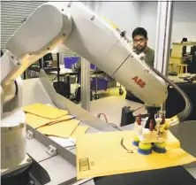  ?? Bob Owen / Hearst Newspapers ?? Abhijit Majumdar, AI/vision developer at Plus One Robotics, demonstrat­es the PickOne, a Swiss-made robot that sorts out cluttered packages, which uses software developed by Plus One.