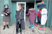  ?? NANCY LANE / BOSTON HERALD FILE ?? Lorraine O’Brien and Susan Johansen are greeted by Red Sox mascot ‘Wally’ outside Fenway Park vaccinatio­n site on Feb. 1 after they were vaccinated. The Fenway cost of $540,013 includes $235,046 in expenses plus a $304,967 minimum weekly payment for vaccine administra­tion.