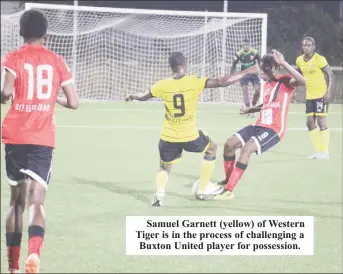  ?? ?? Samuel Garnett (yellow) of Western Tiger is in the process of challengin­g a Buxton United player for possession.
