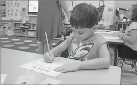  ?? Kristina Wilder / Rome News-Tribune ?? James Timms draws a picture of himself on the first day of school at Anna K. Davie.