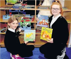  ?? 020217FALL­IN_02 ?? Good read library Pupils Karmen McQuillian and Haylie Graham enjoying time in the new