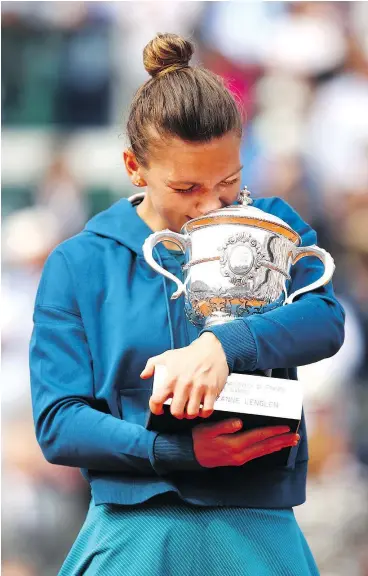  ?? CAMERON SPENCER/GETTY IMAGES ?? Romanian Simona Halep was overjoyed following her victory at the French Open, hugging the trophy and letting her emotions pour out.