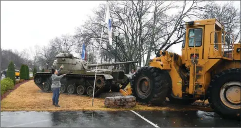  ?? The Sentinel-Record/Mara Kuhn ?? NEW HOME: Employees of Arkansas Aggregates use a CAT 988 wheel loader to maneuver the Purple Heart battle tank onto its new resting spot beside the Garland County Veterans Memorial and Military Park Friday. The tank, which was dedicated as a memorial...