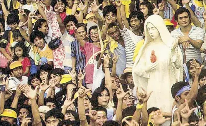  ??  ?? Photo courtesy of Namfrel shows people bringing the image of the Virgin Mary to EDSA as they prayed for the tanks to roll back at the height of people power. Inset shows EDSA hero Fidel Ramos jumping for joy upon learning that Marcos and his family had fled Malacañang on Feb. 25, 1986.