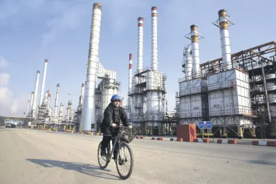  ??  ?? An Iranian oil worker rides his bicycle at the Tehran oil refinery, south of the capital Tehran.