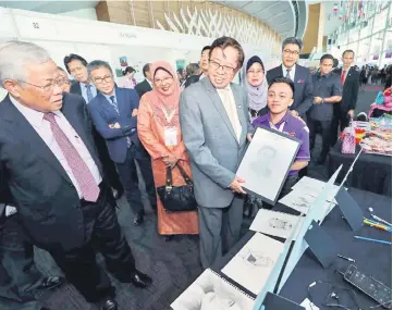  ??  ?? Abang Johari shows a portrait of himself to Manyin. Also seen from second left are Mussen, Dr Annuar, Yasmin and Fatimah.