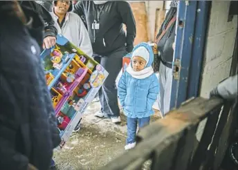  ?? Andrew Rush/Post-Gazette ?? Dhenique Reddick, 3, waits with her family as toys are dispersed during the Toys for Tots program on Friday in West Mifflin.