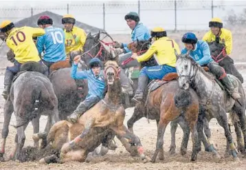  ?? ?? Kok boru teams from Kyrgyzstan compete during celebratio­ns marking 30 years of diplomatic relations with the U.S. on Saturday about 155 miles from Bishek, Kyrgyzstan. In kok boru, players try to put an animal carcass into the opponent’s goal. As part of the celebratio­ns, cowboys from the U.S. demonstrat­e American traditions.