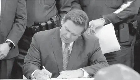  ?? COURTESY ?? Florida Gov. Ron DeSantis signed the“anti-riot”bill on Monday in Winter Haven at the Polk County Sheriff’s Office.