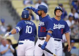  ?? MARK J. TERRILL — THE ASSOCIATED PRESS ?? The Dodgers’ Justin Turner, left, is congratula­ted by Adrian Gonzalez, center, and Corey Seager after hitting a two-run home run against the Angels during the first inning April 1 in Los Angeles. The Dodgers have the highest payroll in baseball this...