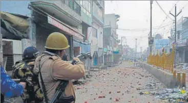  ?? ASHISH KANOJIA/ HT PHOTO ?? ■
A policeman opens fire to control a rioting mob in Meerut.