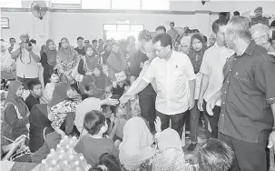  ??  ?? AMBIL IKTIBAR: Shafie (tengah) melawat mangsa-mangsa kebakaran Kampung Air di Semporna.