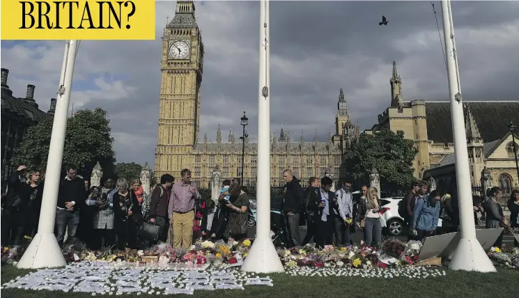  ?? DANIEL LEAL-OLIVAS / AFP / GETTY IMAGES ?? Floral tributes and candles are laid in remembranc­e of slain British MP Jo Cox in front of the Houses of Parliament in London on Friday.
