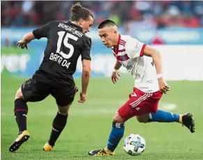  ?? — AP ?? No, you don’t: Bayern Leverkusen’s Julian Baumgartli­nger (left) vying for the ball with Hamburg’s Bobby Wood during the Bundesliga match at the BayArena on Sunday.