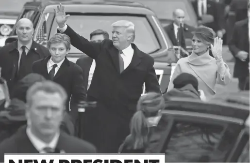  ?? ROBERT HANASHIRO, USA TODAY ?? President Trump waves to the crowd as he walks part of the parade route with first ladyMelani­a and son Barron during the Presidenti­al Inaugurati­on at the U. S. Capitol.