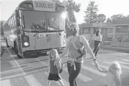  ?? RICK BOWMER/AP ?? Sandra Young and daughters Baylin, 5, and Paytin, 2, arrive at school in Salt Lake City, where the mayor imposed a mask mandate on schools despite Utah’s mandate ban.