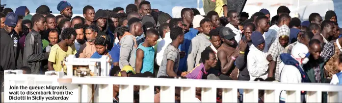  ??  ?? Join the queue: Migrants wait to disembark from the Diciotti in Sicily yesterday