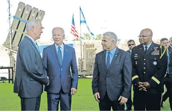  ?? Gon CKhen-Magen / AP ?? Biden entre el ministre de Defensa, Benny Gantz, i el premier Yair Lapid, amb una bateria antimíssil­s Cúpula de Ferro al fons