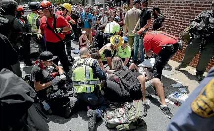  ?? PHOTO: GETTY IMAGES ?? Emergency workers tend to people who were injured when a car ploughed through anti-fascist counter-demonstrat­ors marching through Charlottes­ville.