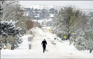  ?? JENNY SPARKS / Loveland Reporter-herald ?? Emily Sullivan of Loveland runs in the snow and freezing cold on West 22nd Street near Farisita Drive in west Loveland on Monday. Sullivan said she runs every day, rain or shine, and she enjoys running in the cold.