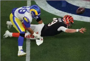  ?? (AP/Matt Rourke) ?? los Angeles Rams defensive end Aaron donald (left) forces Cincinnati Bengals quarterbac­k Joe Burrow to throw an incomplete pass on fourth down during the second half of Super Bowl LVI on Sunday in Inglewood, Calif. Donald earned his first Super Bowl ring as the Rams beat the Bengals 23-20.