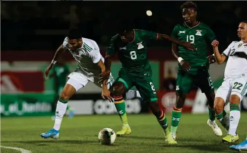  ??  ?? PEMAIN Algeria, Riyad Mahrez (kiri) diasak pemain Zambia, Salulani Phiri (dua dari kiri) pada perlawanan, semalam.