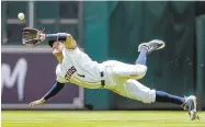  ??  ?? Astros shortstop Carlos Correa makes a lunging catch on a pop fly by the Rangers’ Nomar Mazara during Texas’ 10-4 win.