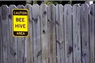  ??  ?? Visitors at Two Rivers Park get fair warning at the Cooperativ­e Extension Service’s bee research station. Scientist Jon Zawislak suggests light-colored clothing is best when working around bees. Dark clothes make bees think a human is a bear, he says.