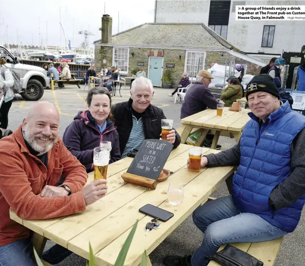  ?? Hugh Hastings ?? A group of friends enjoy a drink together at The Front pub on Custom House Quay, in Falmouth