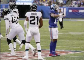  ?? SETH WENIG — ASSOCIATED PRESS ?? Giants wide receiver Odell Beckham celebrates after making a catch as Jaguars defensive back A.J. Bouye, center, and Barry Church walk away during the first half of Sunday’s game at East Rutherford, N.J.