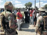  ??  ?? Soldiers engage with civilians on the need for social distancing during the lockdown.