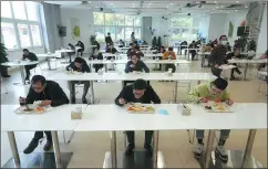  ?? GAO ERQIANG / CHINA DAILY ?? Left: Employees of FESTO China keep a distance at lunch tables after the company resumed operations in Shanghai.