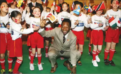  ?? MARK RALSTON / AFP ?? Brazilian soccer legend Pele poses with a group of children during a promotiona­l event in Shanghai on Feb 27, 2006, in relation to the 2006 World Cup in Germany.