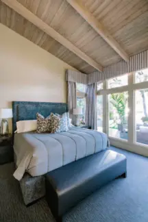  ??  ?? Warm and Woodsy Zebrawood on the kitchen cabinets was chosen for its tight grain, providing great contrast to the original wood ceilings (above). In the master, cozy linens provide a welcome retreat at the end of the day (right).