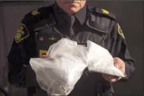  ?? The Canadian Press ?? An Ontario Provincial Police officer displays bags containing fentanyl during a press conference in Vaughan, Ont., last February. Canada’s chief public health officer says the need to increase access to a “safer supply” of opioids is being reviewed with provinces and territorie­s.