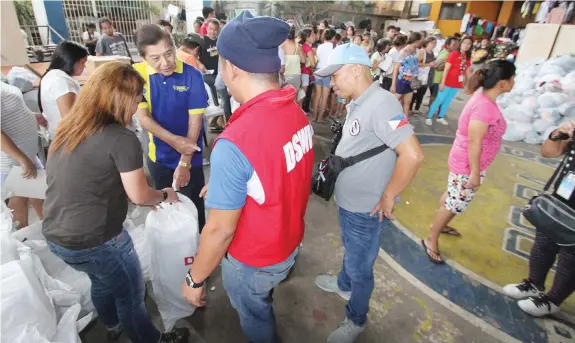  ??  ?? Cebu City North District Representa­vie Raul del Mar leads the distributi­on of relief and food assistance to victims of the fire that hit Barangay Kamputhaw recently. JOY TORREJOS