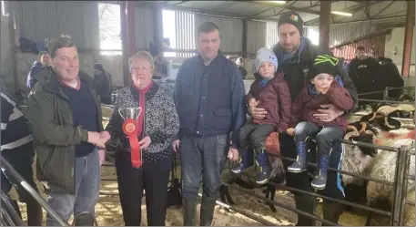  ??  ?? Frances Neary presents the John Neary pepertual Cup to Noel Gallagher, Louisberg, Co. Mayo for the best pen of Ewe Lambs also included in the photo is Anthony Neary and Joseph Neary with his identical twins boys, Charlie and Daithi.