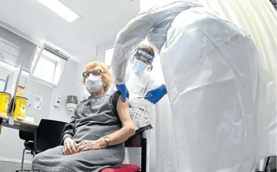  ?? Foto: Efe ?? Vacunación de una mujer mayor de 80 años, grupo que inició ayer las inoculacio­nes, en un centro de salud de Madrid.
