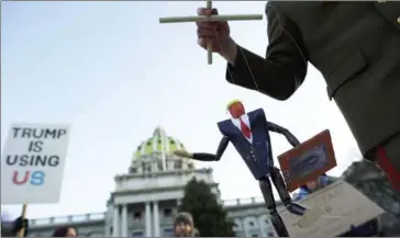  ?? MARK MAKELA/GETTY IMAGES/AFP ?? Scott Greges, 35, dressed as Joseph Stalin, holds a marionette puppet of Donald Trump, joining protestors demonstrat­ing outside the Pennsylvan­ia Capitol Building before electors arrive on Monday to cast their votes from the election in Harrisburg,...