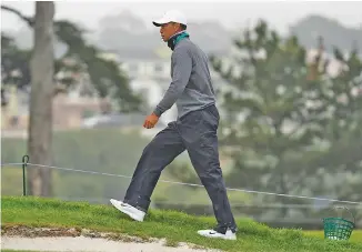  ?? AP PHOTO/JEFF CHIU ?? Tiger Woods walks along a green during Tuesday’s practice for the PGA Championsh­ip at TPC Harding Park in San Francisco.