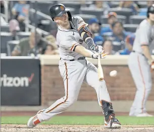  ?? JIM MCISAAC — GETTY IMAGES ?? The Giants’ Buster Posey connects on a base hit in the fourth inning against the Mets on Tuesday in New York. Posey left the game in the fifth inning with right knee discomfort.