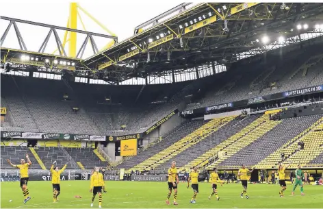  ?? FOTO: MARTIN MEISSNER/DPA ?? Ungewohnte­r Derbysieg-Jubel: Die Dortmunder Spieler feiern nach dem 4:0 gegen Schalke vor der leeren Südtribüne­n, als wären Fans da.