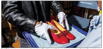  ?? (The New York Times/Roger Kisby) ?? Todd Fisher holds a pair of ruby slippers from “The Wizard of Oz,” part of the late actress Debbie Reynolds’ extensive costume and prop collection, in Las Vegas, Oct. 20, 2020.